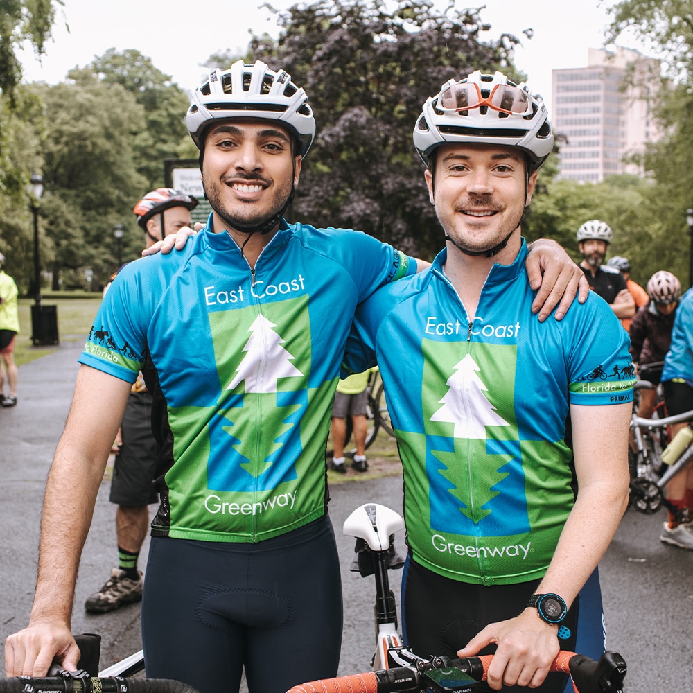 People smiling on the Greenway with matching East Coast Greenway jerseys on