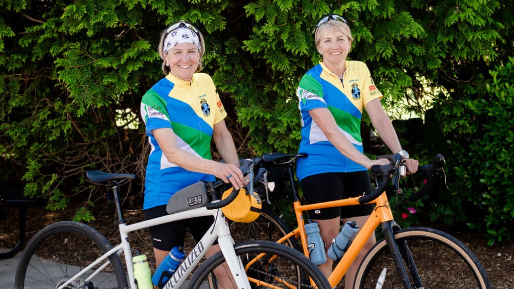Two women smiling with bicycles